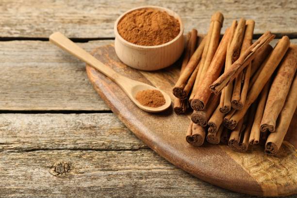 istock Cinnamon powder and sticks on wooden table. Space for text 2177324457
