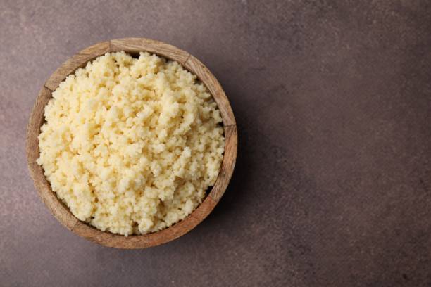 istock Tasty couscous in bowl on brown table, top view. Space for text 2177325185
