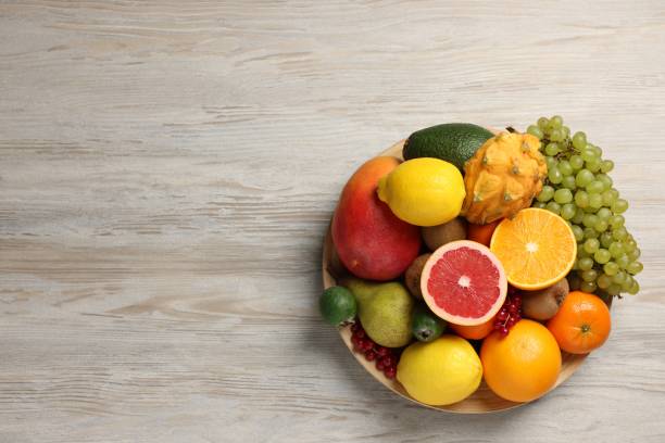 istock Different ripe fruits and berries on light wooden table, top view. Space for text 2177326549