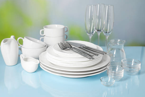 istock Set of clean dishes, glasses and cutlery on light blue table 2177326559