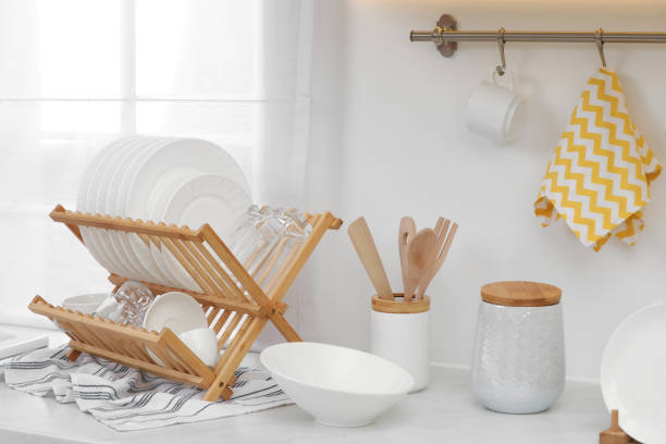 istock Drying rack with clean dishes on countertop in kitchen 2177326565