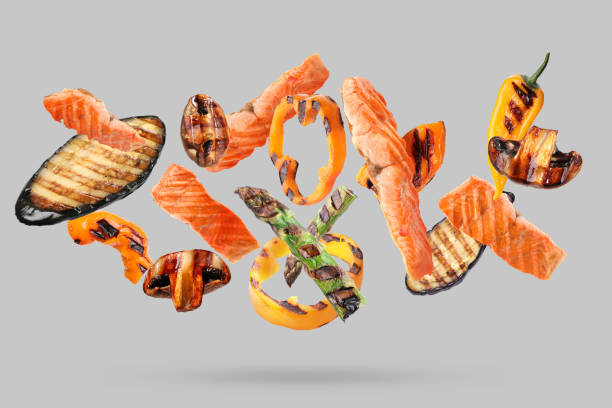 istock Delicious grilled salmon and vegetables falling on grey background 2177326603