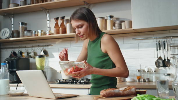 istock Freelancer working kitchen eating salad at home. Serious woman looking laptop 2177326894