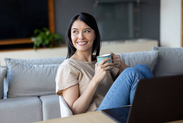 istock Happy woman drinking coffee while working at home on her laptop 2177327260