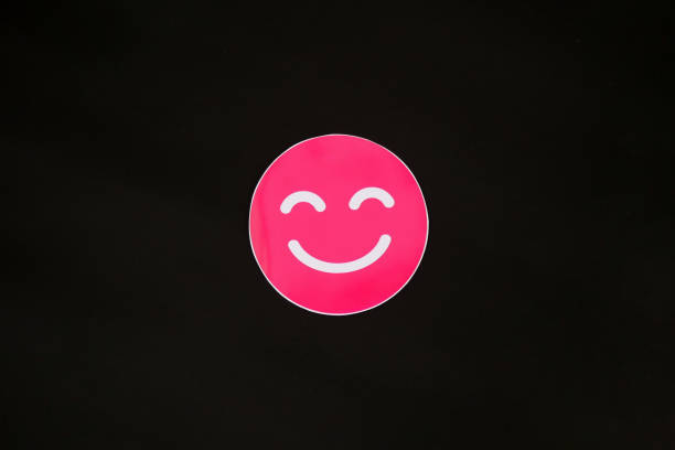 Pink smiling emoji isolated on black background