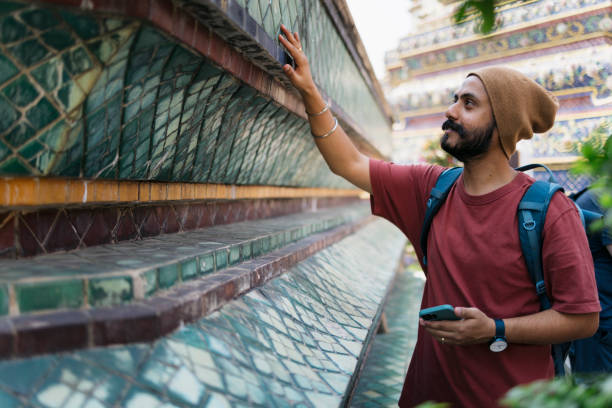 Indian man exploring ancient architecture in Thailand. Indian man visiting ancient monument in Thailand during his vacation.