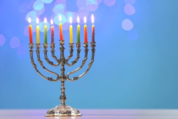 istock Hanukkah celebration. Menorah with burning candles on table against blurred lights, space for text 2177330271