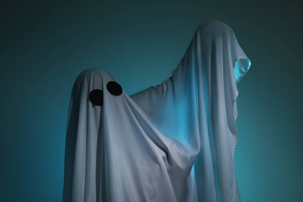 istock Creepy ghost. Woman covered with sheet on dark teal background 2177330370