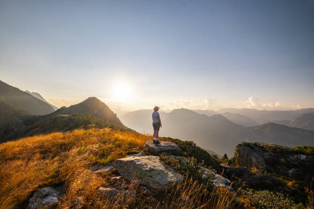 istock Young woman stands on mountain at sunrise 2177331185