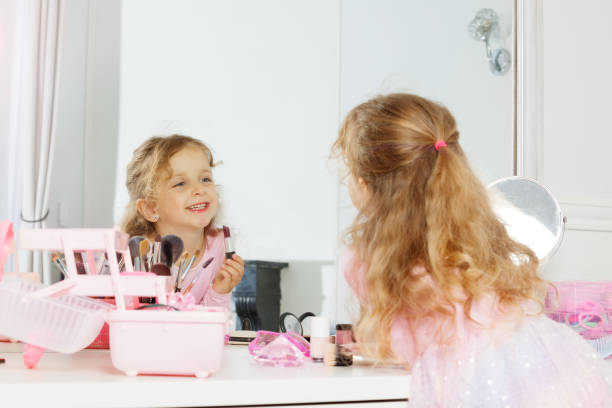 istock She smiles while applying lipstick, pretending to be an adult 2177333523
