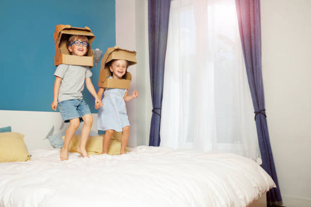 istock Cheerful kids with box helmets pretend to be astronauts in space 2177333652