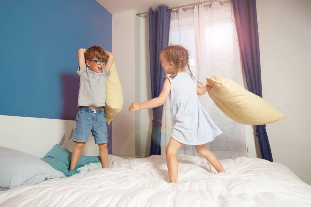 istock Siblings having fun with a pillow fight in their parents bedroom 2177333716