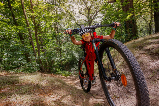 istock Cyclist kid in red pushing mountain bicycle up a wooded path 2177333723