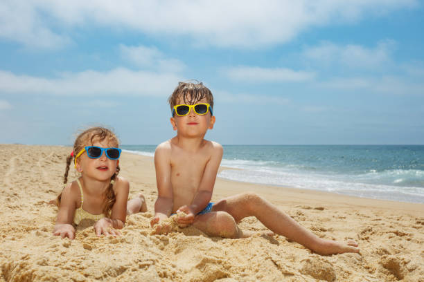istock Children siblings with sunglasses having fun on sunny beach day 2177334005