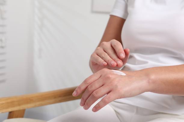 istock Woman applying cosmetic cream onto hand on blurred background, closeup. Space for text 2177334632