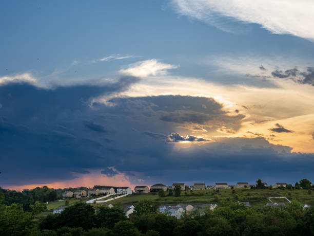 istock Warm sunglow at sunset over American neighborhod with dark thunder storm clouds approaching. 2177339390