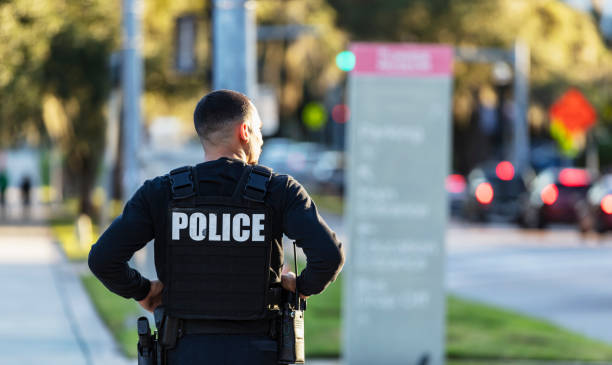 istock Hispanic police officer walking on a sidewalk 2177343933