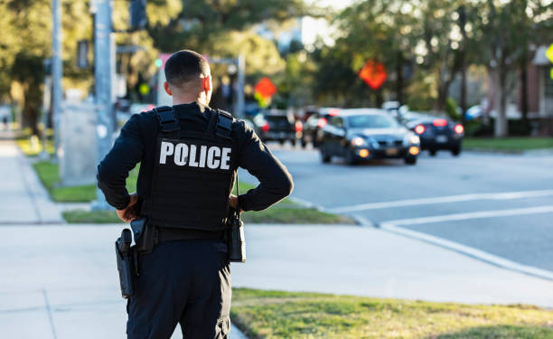istock Hispanic police officer walking on a sidewalk 2177343936