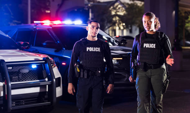 istock Two multiracial police officers working outdoors at night 2177343969