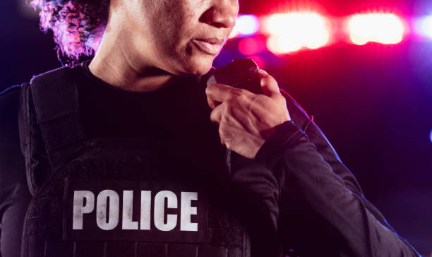 istock Multiracial policewoman talking on radio at night 2177343973