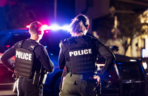 istock Two multiracial police officers working outdoors at night 2177343977