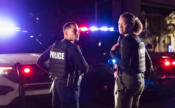 istock Two multiracial police officers working outdoors at night 2177343986