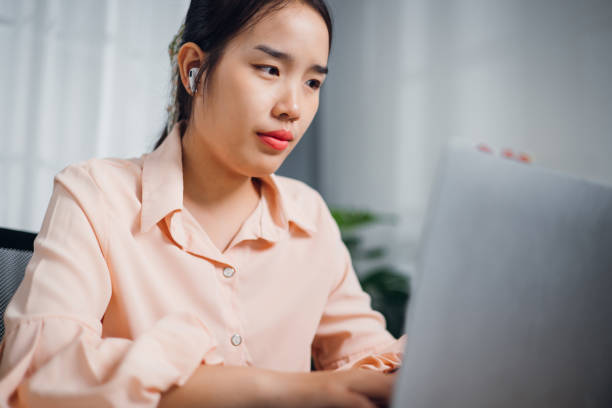 istock Young asian woman sitting at desk thinking idea while working on laptop in modern office. 2177344357