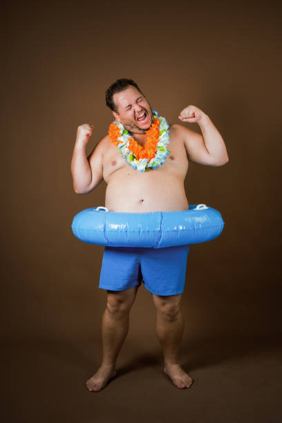 istock Funny fat man with an inflatable ring is going on vacation. 2177352662