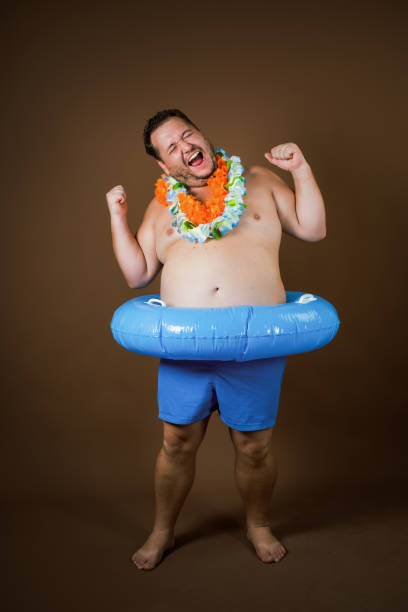 istock Funny fat man with an inflatable ring is going on vacation. 2177352690