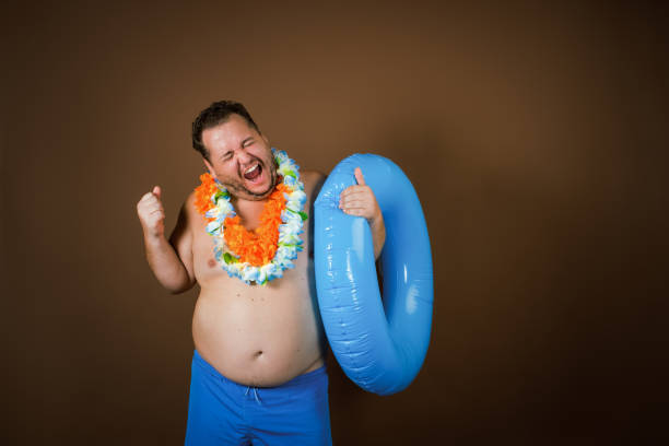istock Funny fat man with an inflatable ring is going on vacation. 2177352739
