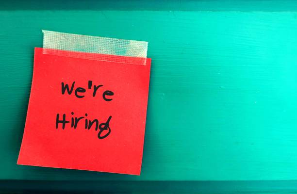 istock Red paper note with  text written WE'RE HIRING sticking on the green board wall with blank copy space - concept of business expanding and looking to hire worker or employee 2177352848