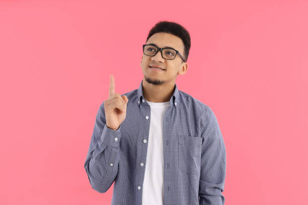istock Young man in glasses on pink background 2177361541