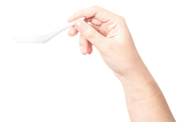 istock Female hand holding a white plastic spoon isolated on white background. 2177362752