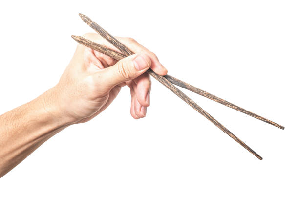 Close-up of a traditional Chinese bowl and chopsticks, held by a hand, savoring a delicious meal in a cozy dining atmosphere