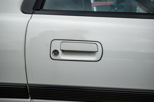 Generic 1990s young timer car door handle with keyhole. Close up front view shot, no people.