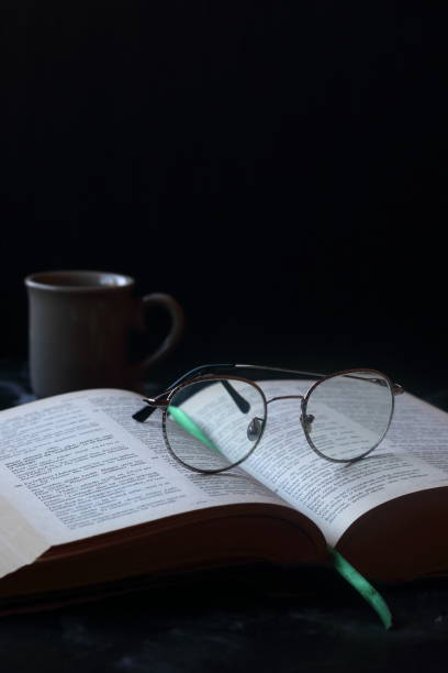 istock A thick book and glasses om a black background 2177369362