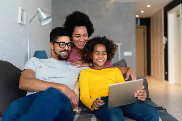 istock Happy black family having fun with digital device at home. People technology happiness concept. 2177369455