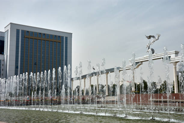 Amazing view of the wonderful fountain in Mustaqillik Maydoni (Independence Square) of Tashkent, Uzbekistan. The Monument to the Ministry of Tourism and Culture and the Storks are visible on a blue sky background.