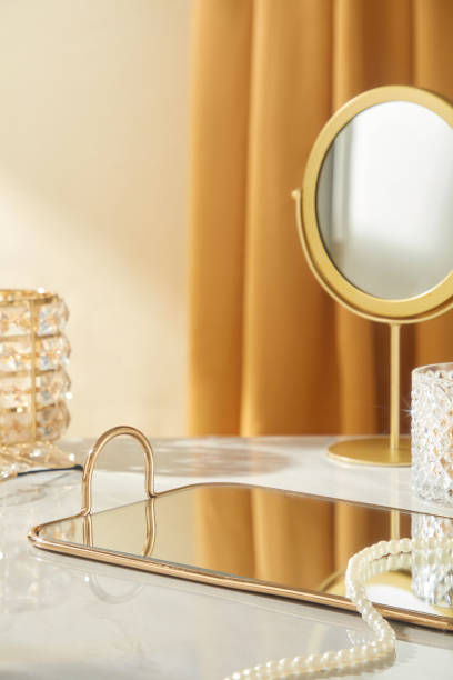 istock The template photo with luxurious ambiance, making it perfect for displaying products, features a close-up of a mirrored tray on a white table, next to a pearl string, a glass cup, and a mirror. 2177369796