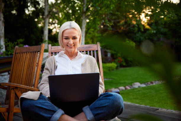 istock Mature woman in backyard patio using laptop 2177373125