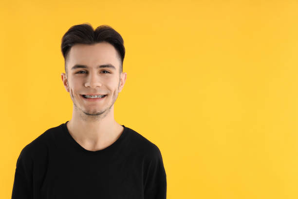 istock Attractive young man in t-shirt on yellow background 2177375861