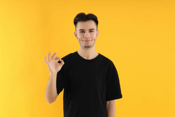 istock Attractive young man in t-shirt on yellow background 2177376154