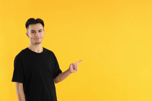 istock Attractive young man in t-shirt on yellow background 2177376491