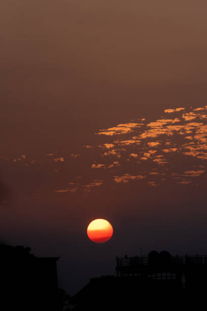 istock Sunset over Dehradun City with burning orange sun and scattered clouds 2177376688