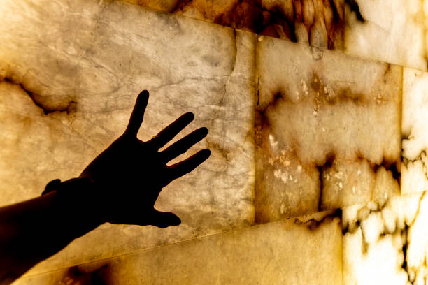 Diffused male hand behind frosted glass