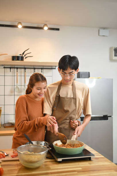 istock Happy young couple enjoying time together while preparing meal in a cozy kitchen 2177381304