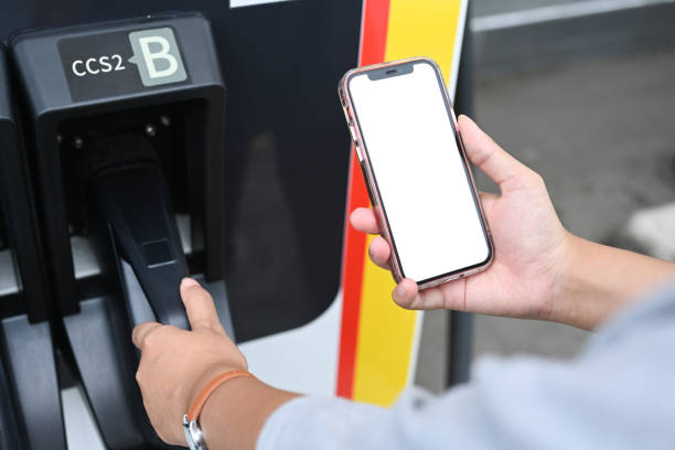 istock Young woman using smartphone while charging electric car at EV charging station 2177381468