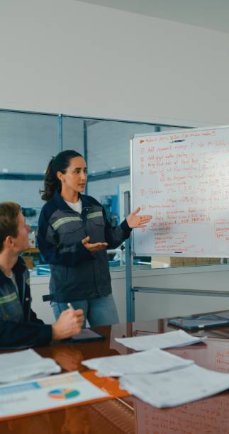 istock Group of engineers having meeting in factory, using whiteboard for discussing project details and planning. Robotic Industrial Factory. 2177384065