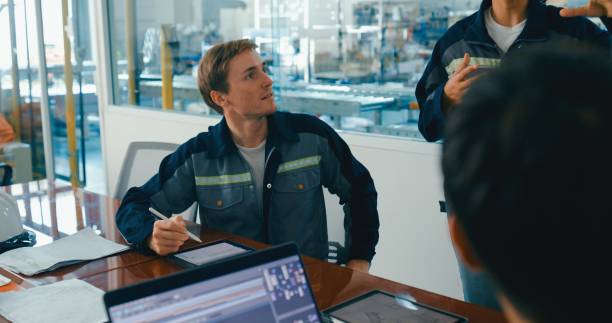 istock Group of engineers having meeting in factory, using whiteboard for discussing project details and planning. Robotic Industrial Factory. 2177384070