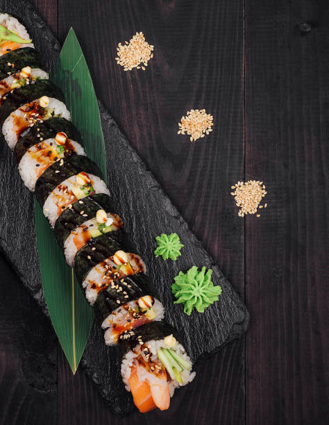 istock Sushi rolls set served on black stone plate on dark wooden background 2177384160